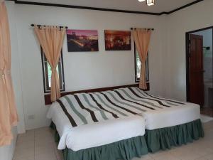 拜县บ้านพาสุขรีสอร์ท的一间带大床和两扇窗户的卧室