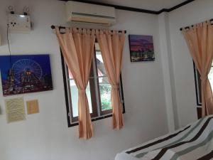 Postel nebo postele na pokoji v ubytování บ้านพาสุขรีสอร์ท