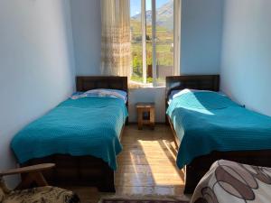 two beds in a room with a window at Villa QALDEA in Ushguli
