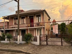 a pink house with a fence in front of it at Tazo's Guest House in Kobuleti