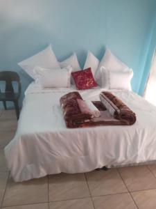a white bed with blankets and pillows on it at Arcon Guest House in Vanderbijlpark +21 photos