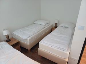 Dos camas en una habitación con sábanas y almohadas blancas. en Apartament nr 186 Geyersberg, en Freyung 12 fotos más