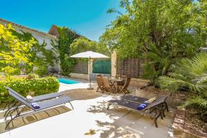 カプタングにあるVilla La Fontaine by Villa Plusのテーブルと椅子と傘のあるパティオ