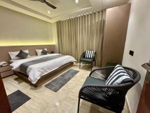a bedroom with a bed and two chairs in it at Ganga Euphoria - A Luxury Villa on the Ganges in Rishīkesh