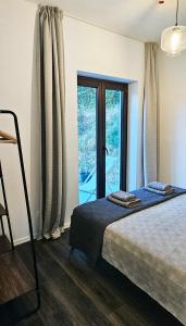 una camera da letto con un letto e una porta scorrevole in vetro di Rosemarin Green a Capodistria