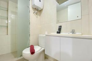 a bathroom with a white toilet and a sink at Spacious and Homey 3BR at Springlake Summarecon Bekasi Apartment By Travelio in Bekasi +12 photos