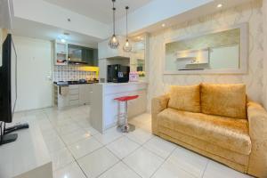 a living room with a couch and a kitchen at Spacious and Homey 3BR at Springlake Summarecon Bekasi Apartment By Travelio in Bekasi