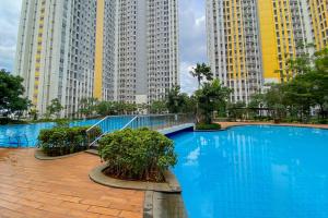 a swimming pool in a city with tall buildings at Spacious and Homey 3BR at Springlake Summarecon Bekasi Apartment By Travelio in Bekasi