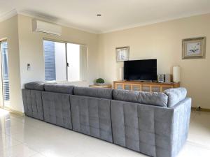 a large couch in a living room with a television at Unit 27 Seafront Estate in Jurien Bay