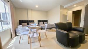 a living room with a table and chairs and a couch at Como Homestay Batam in Batam Center