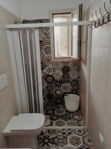 bagno con servizi igienici e parete piastrellata di Casa Relax Torre Pali a Torre Pali