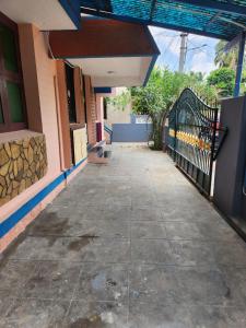an empty sidewalk outside a building with a gate at Holiday Home Madurai CS Nagar - GF in Madurai +20 photos