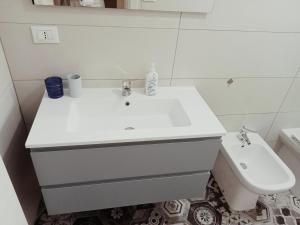 un bagno bianco con lavandino e WC di Casa Relax Torre Pali a Torre Pali Altre 3 foto