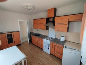 a kitchen with wooden cabinets and white appliances at Sweet home in Tauragė