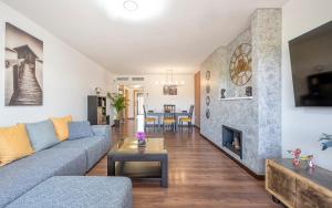 een woonkamer met een bank en een open haard bij Apartamento Las Joyas in Estepona
