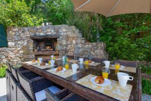 a table with plates of food and a stone fireplace at Villa Cabris by Villa Plus in Cabris
