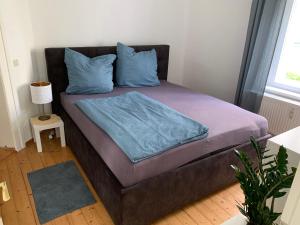 a bed with a blue blanket on it in a room at Ferienwohnung am Tivoli in Freiberg