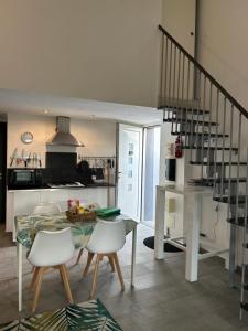 cocina con mesa y sillas blancas en Chez Muriel, en Porto Vecchio