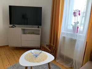 a living room with a tv and a table with a bowl on it at Ferienwohnung am Tivoli in Freiberg