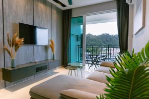 a living room with a couch and a tv at Trival Property Homestay Sri Indah Sandakan in Sandakan