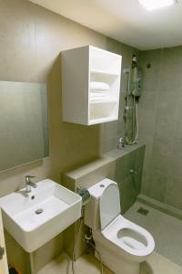 a bathroom with a white toilet and a sink at Trival Misty Cottage Homestay Sri Indah Sandakan in Sandakan