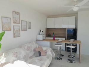 Una sala de estar con un sofá y una cocina. en La PLage, en Port-la-Nouvelle