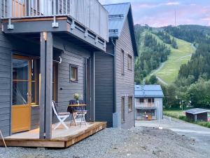 菲奈斯达伦Funäsdalshöjden Funäsdalen的房屋设有1个带桌子和椅子的甲板