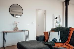 a living room with a couch and a mirror at Hobart Luxury Family Home with Spa & Fire Pit, Sleeps 8 in Sorell +71 photos