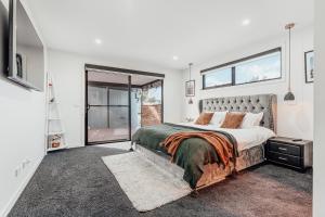 a bedroom with a large bed and a window at Hobart Luxury Family Home with Spa & Fire Pit, Sleeps 8 in Sorell