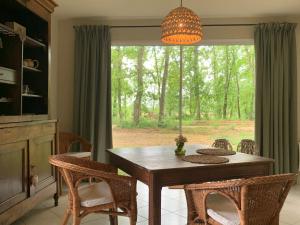 a dining room with a table and chairs and a window at Le Buscagneau in Béraut