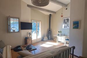 a living room with a couch and a table at Maison bord de mer - piscine - in Théoule-sur-Mer