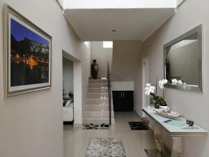 a hallway with a staircase and a mirror at JoJo's BnB in Mossel Bay +138 photos