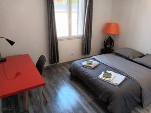 a bedroom with a bed and a desk and a red table at Maison au calme avec piscine in Alleins +10 photos