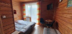 ein Schlafzimmer mit einem Bett und einem Tisch und einem Fenster in der Unterkunft Diablak in Zawoja + 24 Fotos