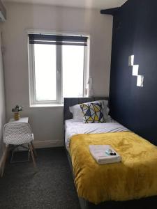 ストックトン・オン・ティーズにあるWelcoming Oaklandのベッドルーム1室(黄色い毛布と窓付)