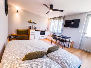 a bedroom with a large bed and a kitchen at SERENITY Suite in Vénissieux