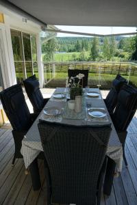 un tavolo e sedie su un portico con tavolo e sedie di Tranquil Lakeside Cottage Retreat i Garpenberg a Garpenberg