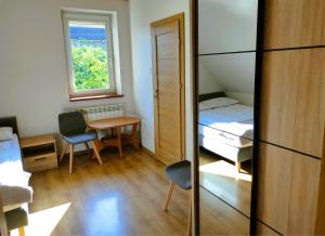 a small room with a bed and a table and a window at Pokoje gościnne Zawoja Centrum Henryk Hadka in Zawoja