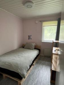 una camera da letto con un letto e una finestra di Tranquil Lakeside Cottage Retreat i Garpenberg a Garpenberg
