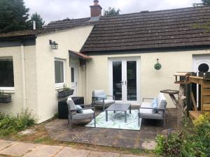 eine Terrasse mit Stühlen und einem Tisch vor einem Haus in der Unterkunft Cottage in heart of Perthshire in New Scone