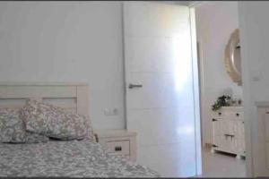 Un dormitorio con una cama, una cómoda y un armario. en Apartamento Casa Capricho en El Verger Denia, en El Verger