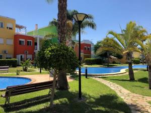 un parque con un banco y palmeras y un edificio en Apartamento Casa Capricho en El Verger Denia, en El Verger 22 fotos más