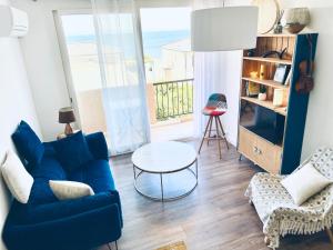 a living room with a blue couch and a table at Grand Bleu, Vue sur Lac, Cosy et Chic WIFI Centre ville, Plage in Istres