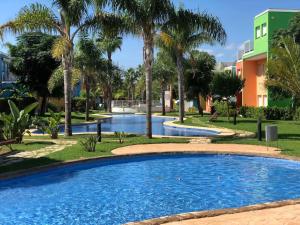 una piscina en un parque con palmeras en Apartamento Casa Capricho en El Verger Denia, en El Verger