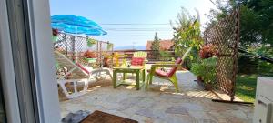 a patio with a table and chairs and an umbrella at Lovely place with a view of Skopje in Skopje