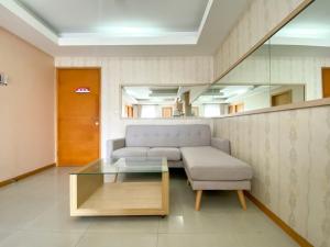 a living room with a couch and a glass coffee table at Comfort 2BR at 6th Floor Metropark Condominium Jababeka Apartment By Travelio in Cikarang +13 photos