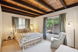 ein Schlafzimmer mit einem Bett, einem Fenster und einem Stuhl in der Unterkunft Warm and Cozy Mountain and Lake View Haven cottage in Kelseyville