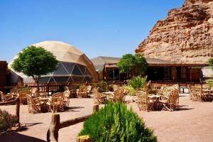 a group of tables and chairs in front of a building at Hasan Zawaideh Camp in Wadi Rum