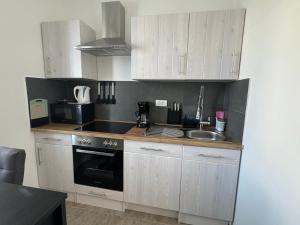 a kitchen with white cabinets and a sink and a stove at Apartment Block Two in Šibenik