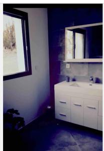 a bathroom with a white sink and a window at Appartement in Vignale